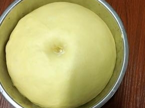 面团滚圆盖上保鲜膜发酵至原来的两倍大