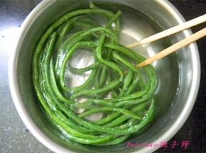 将烫熟的豇豆捞在凉水里过凉；