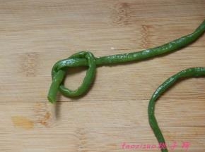 开始打豇豆结：取一根豇豆，在一端先打个活结，活接的圈如图所示；