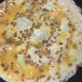 转圈淋入鸡蛋液，中火煎制。