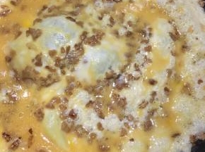 转圈淋入鸡蛋液，中火煎制。