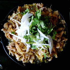 在五花肉都变色之后倒入圆葱丝和香菜段，翻拌。