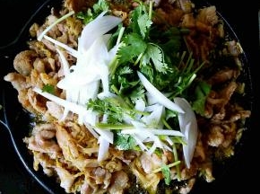 在五花肉都变色之后倒入圆葱丝和香菜段，翻拌。
