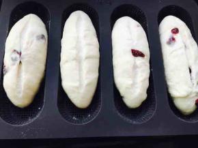 二发后，在面包中间割一道口子，建议割两次，但不要太深，否则会漏出奶酪馅料，遇到蔓越莓挡路，不要硬割，你割不断它滴，让开它，或者扣下来……