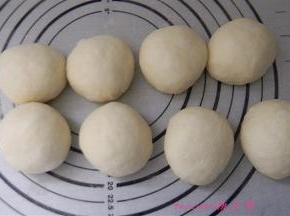 将发好的面包面团按每个70克分成小面团，滚圆后静置30分钟；