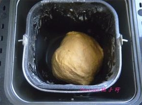 将南瓜泥、蛋液、纯净水、食盐、面包粉、低筋粉、奶粉、糖、干酵母放入面包机内执行揉面程序；