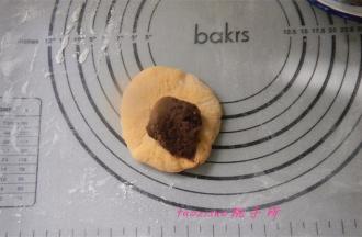 静置后的面团，压扁，包入提前备好的红豆馅；