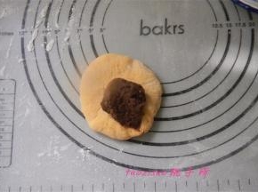 静置后的面团，压扁，包入提前备好的红豆馅；