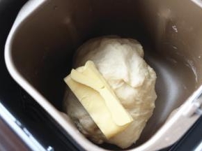 面团可以拉出厚膜，但容易破，达到初步扩展阶段，放入室温软化好的30克黄油，就开启和面程序，设置时间35分钟。