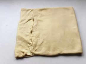 如图在1/8处折上去，另一头也折上去，这样折边缘会比较整齐。