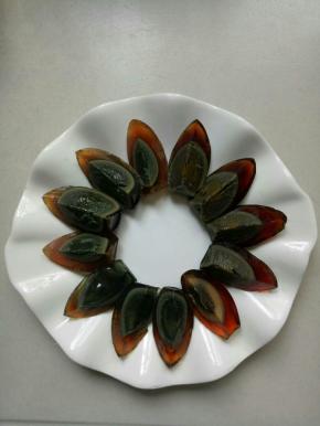 用刀蘸水把皮蛋切成四份，摆在盘中