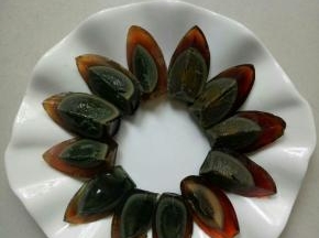用刀蘸水把皮蛋切成四份，摆在盘中
