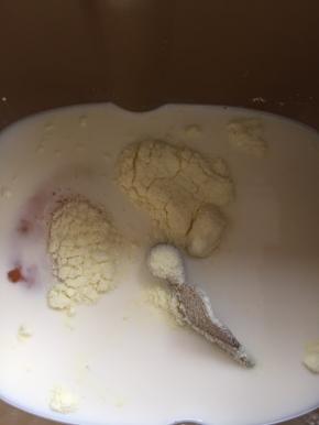 面包桶内加入牛奶、全蛋液、细砂糖、奶粉和盐。