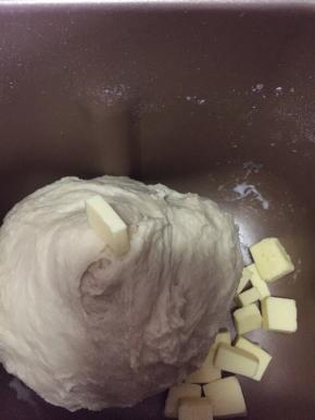 面团揉至光滑，能拉出大片薄膜时加入黄油。