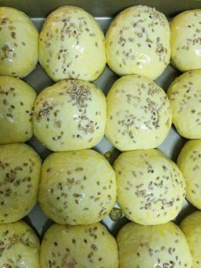 发酵好的面团表面刷蛋液，撒一些白芝麻。