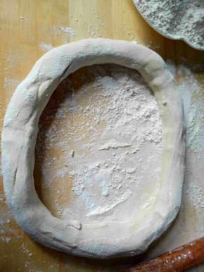 把面团取出，揉圆，中间挖个小洞，慢慢扩大小洞，使其越来越细