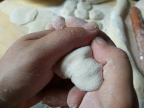 开始包饺子，饺子皮中间放馅，两手这样握住，轻轻一使劲，把饺子皮粘在一起即可