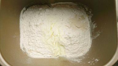 将所有材料除黄油外，按照液体粉类依次放入面包桶，启动揉面功能15分钟