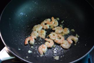 锅中热油，小火爆香蒜末，放入虾仁中火拌炒，淋入料酒