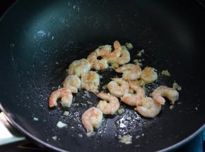 锅中热油，小火爆香蒜末，放入虾仁中火拌炒，淋入料酒
