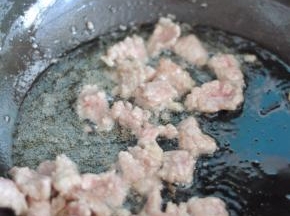 锅里倒入油，放入牛肉快速滑炒至表面变色，捞出备用。