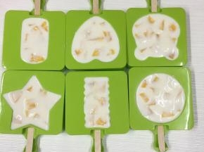 加入芒果丁至满模，用手轻轻按压，使芒果丁与酸奶混合。