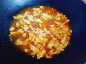 番茄汤已经滚开，加入煎好的鸡蛋。