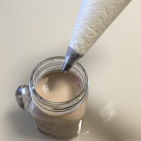 做好的摩卡咖啡倒入自己喜欢的杯子内，裱上一层奶油，从外往里漩涡裱上