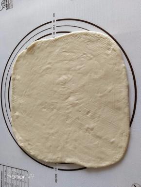 9.	用擀面杖将面团擀卷成圆形。