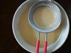 将拌好的面糊过筛。这步很费时的，把里面的小颗粒用刮刀在筛网上用力抵一下，这样就可以把小颗粒过筛过去了。