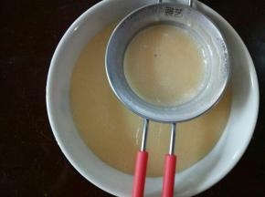 将拌好的面糊过筛。这步很费时的，把里面的小颗粒用刮刀在筛网上用力抵一下，这样就可以把小颗粒过筛过去了。