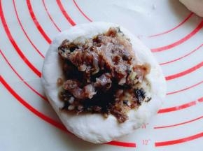 取一小块面团，加入馅料，普通包子的手法，包起来，收口朝下。