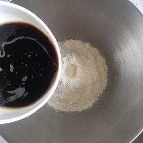中筋面粉放入盆中，中间挖一小孔倒入耐糖活性干酵母，边上倒入1g盐，慢慢倒入红糖水