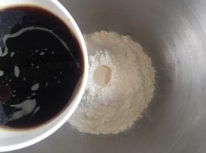 中筋面粉放入盆中，中间挖一小孔倒入耐糖活性干酵母，边上倒入1g盐，慢慢倒入红糖水