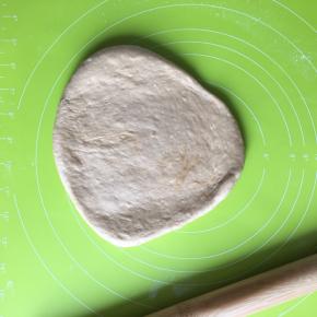 取出面团放在揉面垫上，揉压排出气体