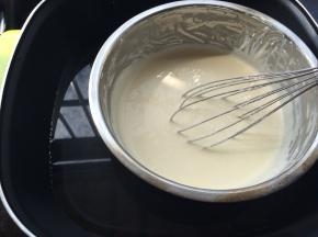 锅中放入适量的水，烧至65-70度左右，隔热水把用手动打蛋器慢慢搅拌至奶油芝士，黄油，牛奶融合为一体，成为无颗粒非常顺滑的芝士糊。