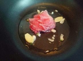 热锅冷油，油温7成时加入葱姜蒜炒香，再把切好的肉片加入锅中小火煸炒。