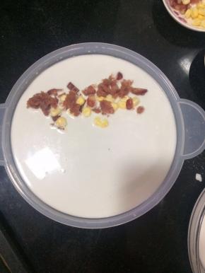 把混合好的粉浆舀一勺倒在班戟盘上，薄薄一层就可以了，不要倒太多，在放上肉末，腊肠，玉米粒