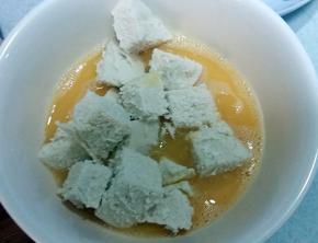 馒头丁放蛋液里转一圈，保证馒头丁每面都裹上蛋液。