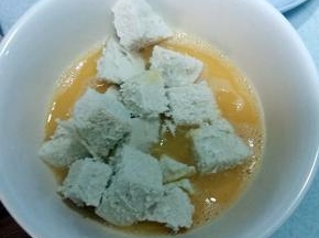 馒头丁放蛋液里转一圈，保证馒头丁每面都裹上蛋液。