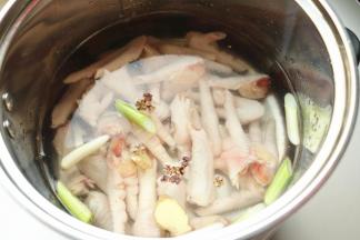 汤锅加水，加葱段姜片和八角一个，放入鸡爪。