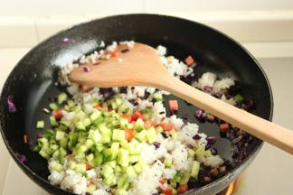 再下入黄瓜丁和香肠丁，继续翻炒半分钟。