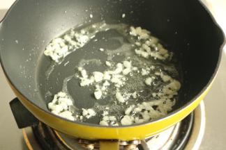 煮面的时候加工一下酱料，炒锅放少量油，爆香蒜末。