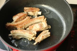 平底锅里放油，下入煮好的排骨开始煎至表金黄。