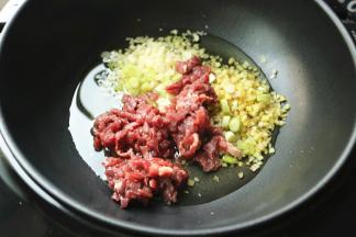 下入葱姜蒜末和牛肉末。