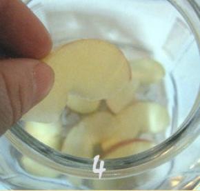 取适量冰糖放在玻璃瓶底，接着把切好的苹果片放在冰糖上面；