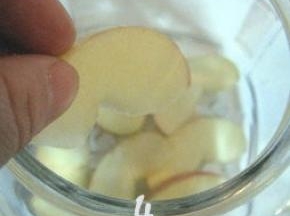 取适量冰糖放在玻璃瓶底，接着把切好的苹果片放在冰糖上面；