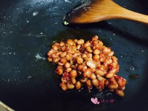 锅内留底油，下入腊八豆炒香，腊八豆本身也有红油，这一步油可以少放点