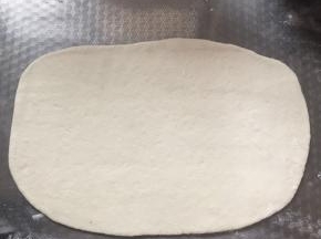 用擀面杖擀成长方形的薄片。