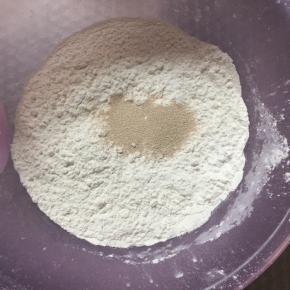 面粉放入盆中，加入酵母搅拌均匀。